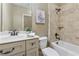 Cozy bathroom with a white vanity, framed art and a tub with tiled shower at 3405 Camellia Ln, Suwanee, GA 30024