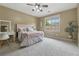 Spacious bedroom featuring a window, ceiling fan, desk and floral decorations at 3405 Camellia Ln, Suwanee, GA 30024