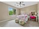 Bright bedroom featuring a ceiling fan, window and floral accent furniture at 3405 Camellia Ln, Suwanee, GA 30024