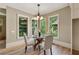 Bright dining room with hardwood floors, a round table, and large windows offering a view of the outdoors at 3405 Camellia Ln, Suwanee, GA 30024