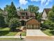 Charming brick home with a well-manicured lawn and a two-car garage, nestled among mature trees at 3405 Camellia Ln, Suwanee, GA 30024