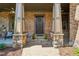 Welcoming front porch with stone columns and a cozy sitting area, perfect for enjoying the outdoors at 3405 Camellia Ln, Suwanee, GA 30024