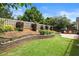 View of the lush backyard with a stone patio, garden beds, and wooden privacy fence at 170 Shelli Ln, Roswell, GA 30075