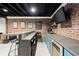 Basement bar area with brick accents, bar stools, beverage fridge and tv at 170 Shelli Ln, Roswell, GA 30075