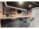 Stylish basement bar area with dark bar, light countertop, exposed brick, and shelving at 170 Shelli Ln, Roswell, GA 30075