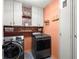 Laundry room with white cabinets, washer and dryer, and trendy wallpaper accent at 170 Shelli Ln, Roswell, GA 30075