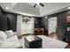 Stylish living room with dark accent walls, tray ceiling, and sliding barn door access to other rooms at 170 Shelli Ln, Roswell, GA 30075