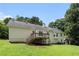 Rear exterior view of a tan two-story house with a deck, patio and large backyard at 350 Dailey Mill Rd, Mcdonough, GA 30253