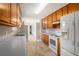 Well-lit kitchen featuring wood cabinets, white appliances, and spacious countertop at 350 Dailey Mill Rd, Mcdonough, GA 30253