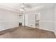 Spacious carpeted primary bedroom with tray ceilings, ceiling fan, and bathroom access at 350 Dailey Mill Rd, Mcdonough, GA 30253