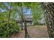 Backyard view showcasing the home's back elevation and two-level deck amidst lush trees and green groundcover at 4098 Charlotte Se Ct, Smyrna, GA 30082