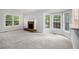 Spacious living room featuring a fireplace, neutral carpet, and large windows at 4098 Charlotte Se Ct, Smyrna, GA 30082