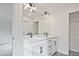 Bright bathroom featuring double sinks with black fixtures, white cabinets and white quartz countertops at 699 Sunstone Ln, Lawrenceville, GA 30043