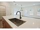 Close-up of the kitchen island with sink, white countertop and view to the front door at 699 Sunstone Ln, Lawrenceville, GA 30043