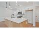 Kitchen island features a white countertop with a dark faucet and modern pendant lights at 699 Sunstone Ln, Lawrenceville, GA 30043
