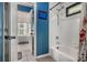 Blue bathroom with a bathtub and shower combo, a framed mirror and tiled floors at 351 Prestbury Ct, Suwanee, GA 30024