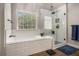 Bright bathroom features a soaking tub, glass-enclosed shower, modern fixtures, and a large window at 351 Prestbury Ct, Suwanee, GA 30024