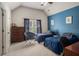 Bedroom featuring two twin beds, a blue accent wall, and large window with dark curtains at 351 Prestbury Ct, Suwanee, GA 30024