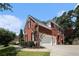 Brick home showing a two-car garage, side entry and well-manicured landscape at 351 Prestbury Ct, Suwanee, GA 30024