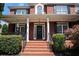 Inviting front porch with brick steps, pillars, and a decorative wreath on the front door at 351 Prestbury Ct, Suwanee, GA 30024