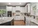 Bright kitchen with white cabinets, granite counters, large farmhouse sink, and stainless steel appliances at 351 Prestbury Ct, Suwanee, GA 30024