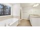 Well-lit bathroom showcases tub, ceramic tile and shower with glass doors, plus vanity storage at 3623 Squires Park Ln, Loganville, GA 30052