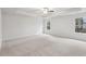 Large, light-filled primary bedroom with plush carpeting, tray ceiling with fan, and large windows at 3623 Squires Park Ln, Loganville, GA 30052