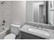 A beautifully renovated bathroom featuring white marble tile, granite countertops, and brushed nickel fixtures at 6176 Hyde Park Ln, Lithonia, GA 30058