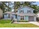 Charming two-story home with light blue siding, gray shutters, attached garage, and well-maintained front lawn at 6176 Hyde Park Ln, Lithonia, GA 30058