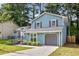 Charming two-story home with light blue siding, gray shutters, attached garage, and well-maintained front lawn at 6176 Hyde Park Ln, Lithonia, GA 30058