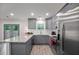 Modern kitchen with gray cabinets, stainless steel appliances, and sleek granite countertops, next to a set of french doors at 6176 Hyde Park Ln, Lithonia, GA 30058