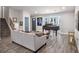 Spacious living room showcasing a modern gray couch, piano, staircase, and large windows at 6176 Hyde Park Ln, Lithonia, GA 30058
