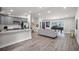 Open-concept living area with stairs, modern kitchen, gray cabinets and a large window at 6176 Hyde Park Ln, Lithonia, GA 30058
