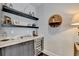 Custom dry bar with white countertops, gray cabinets, open shelving, and a wine refrigerator at 6399 Lucent Ln, Atlanta, GA 30328