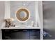 Modern powder room with a round mirror, marble backsplash, and sleek black vanity at 6399 Lucent Ln, Atlanta, GA 30328