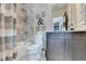 The well-lit bathroom has a shower and tub, with gray accent tile, stylish fixtures, and a decorative motif at 6399 Lucent Ln, Atlanta, GA 30328