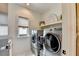 This laundry room features stainless steel front-loading machines and a small window for natural light at 6399 Lucent Ln, Atlanta, GA 30328