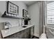 Wet bar featuring white countertop with stainless sink and mini-fridge below floating shelves with decorations at 6399 Lucent Ln, Atlanta, GA 30328