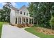 Two-story home featuring a welcoming front porch, gray siding, and a spacious driveway leading to the house at 2214 Meador Ave Se, Atlanta, GA 30315