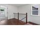 Upstairs hallway with hardwood floors, iron railing, and view to the outside at 2214 Meador Ave Se, Atlanta, GA 30315
