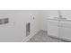 Bright laundry room features patterned tile floor and white cabinetry with stainless faucet at 2214 Meador Ave Se, Atlanta, GA 30315
