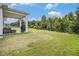 Green backyard featuring an expansive lawn and covered patio, offering a private and serene outdoor space at 2304 Pelham Pass, Dacula, GA 30019