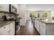 Well-lit kitchen features stainless steel appliances, granite countertops, and dark backsplash at 2304 Pelham Pass, Dacula, GA 30019