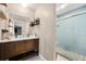 Bathroom with stone floors, light blue tile in shower, and wood vanity at 4323 Japonica Sw Ct, Lilburn, GA 30047