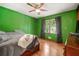 Bedroom with green walls, hardwood floors, ceiling fan, and natural light at 4323 Japonica Sw Ct, Lilburn, GA 30047