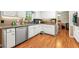 Traditional kitchen with white cabinets, stainless steel dishwasher, and wood-look flooring at 4323 Japonica Sw Ct, Lilburn, GA 30047