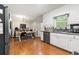 Well-lit kitchen with white cabinets, stainless steel appliances, and hardwood floors at 4323 Japonica Sw Ct, Lilburn, GA 30047