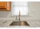 Close-up of a kitchen sink with granite countertops and a modern faucet, showcasing elegant details at 136 Peachtree Memorial Nw Dr # Ri2, Atlanta, GA 30309