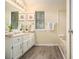 Relaxing bathroom featuring wood floors, white vanity, and luxurious soaking tub at 300 Twin Tendrils Sw, Atlanta, GA 30331