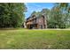 Image of a large grass yard with a view of the home's rear deck and wooded backdrop at 300 Twin Tendrils Sw, Atlanta, GA 30331